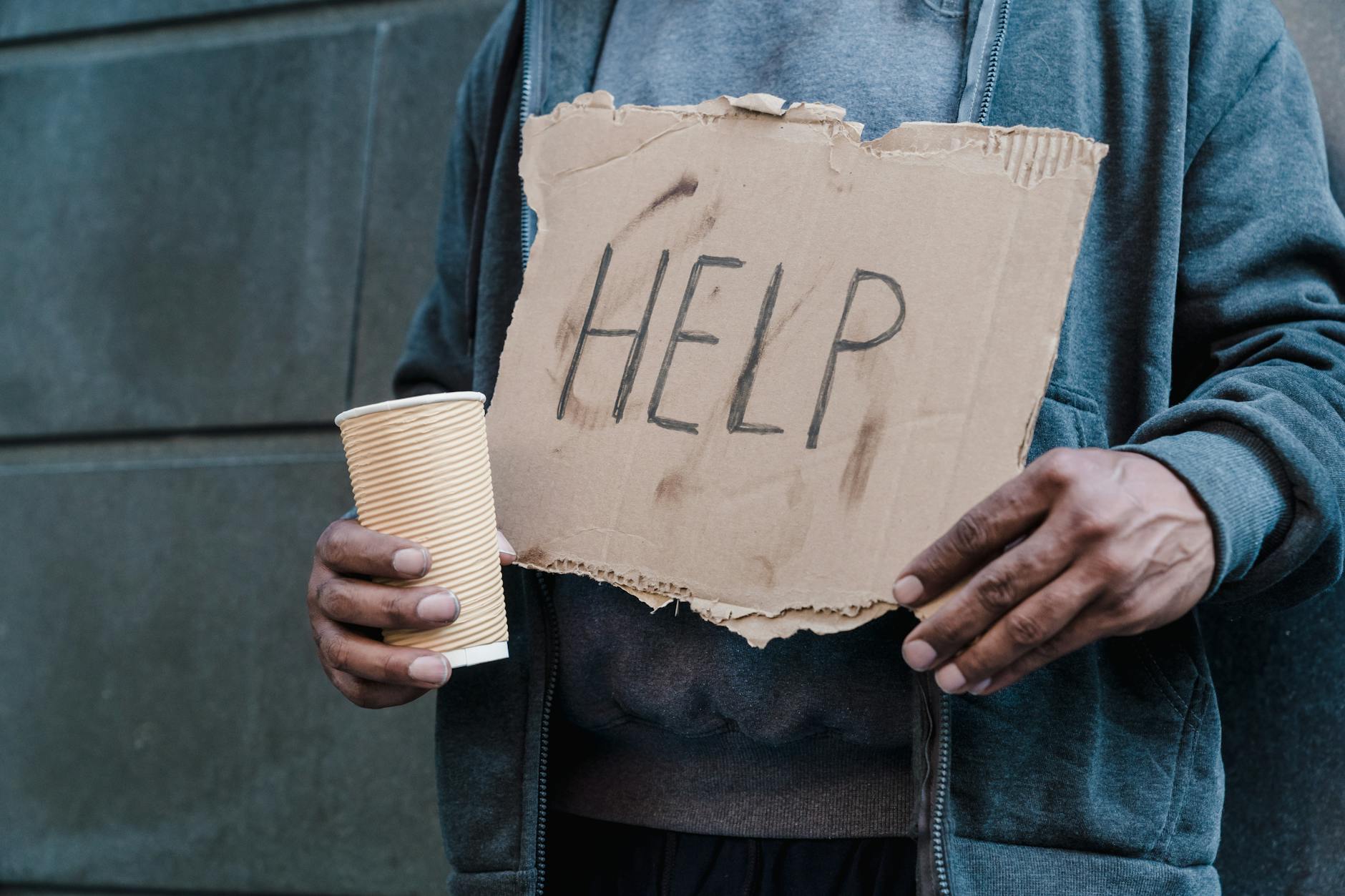 man holding cup and cardboard